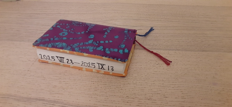An orange and purple journal cover with red and blue book marks.